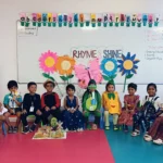 Happy kindergarten children with backpacks at school